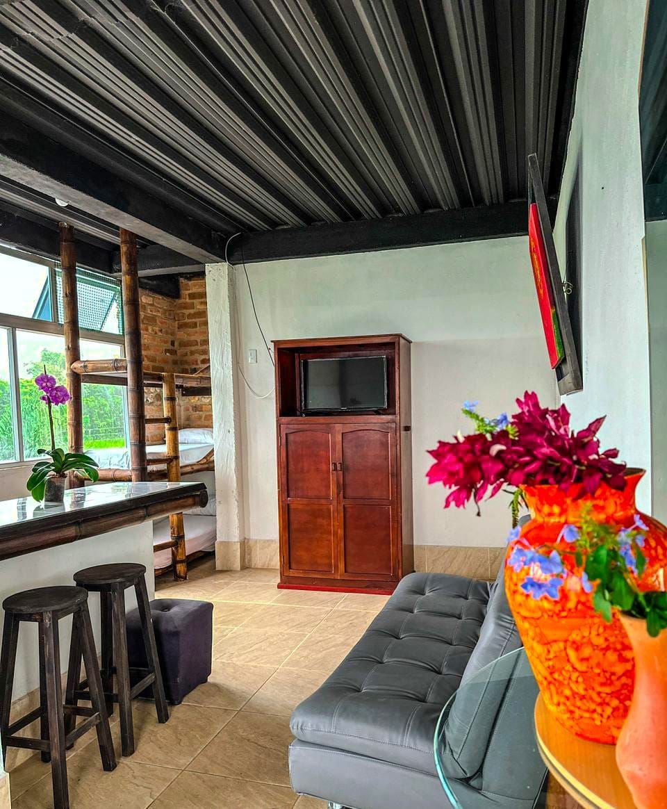 Uma sala de estar moderna com um sofá, um armário de madeira e uma TV fixada na parede.