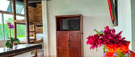 Una sala de estar moderna con un sofá, un mueble de madera y un televisor montado en la pared.