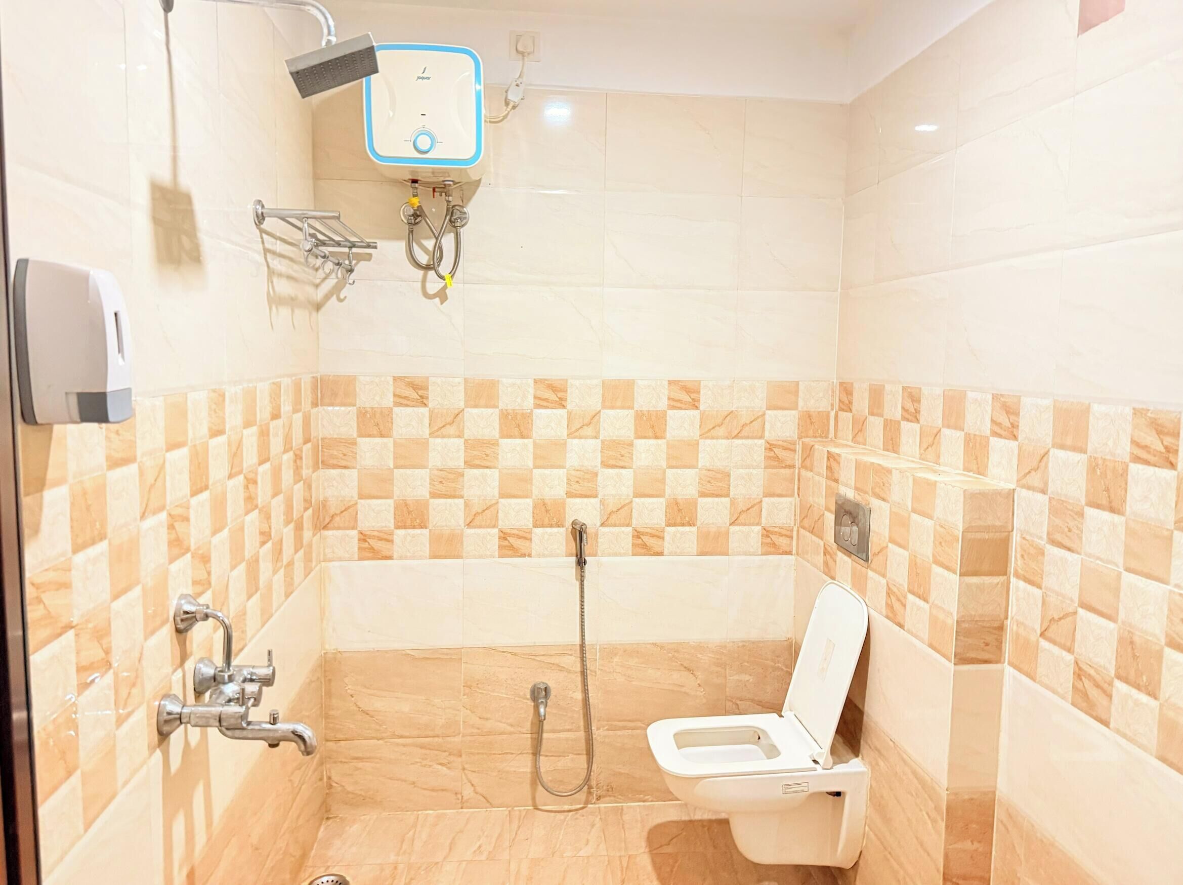 Une salle de bain équipée d’une douche, de toilettes et d’un sèche-mains.