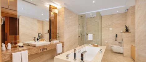 A modern bathroom with two sinks, a large bathtub, and a glass-enclosed shower.