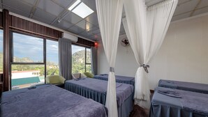 A room with two beds, a chair, and a large window with curtains. - Emerald Retreat Tam Coc (Nam Hoa Lu)