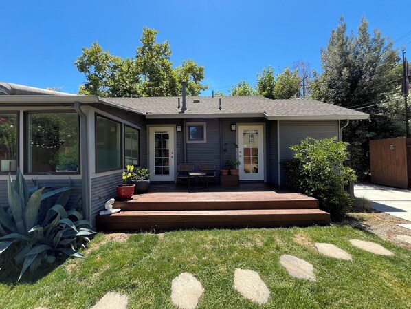 A single-story house with a front porch, a covered patio, and a small garden area.