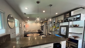 A modern kitchen with a central island, built-in appliances, and a dining area with a round table.