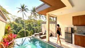 A modern kitchen with a built-in refrigerator and a poolside area with lounge chairs and a view of the surrounding greenery. - AKA Valley Ubud Villas (Ubud)