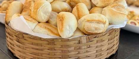 A basket of freshly baked bread rolls on a countertop.