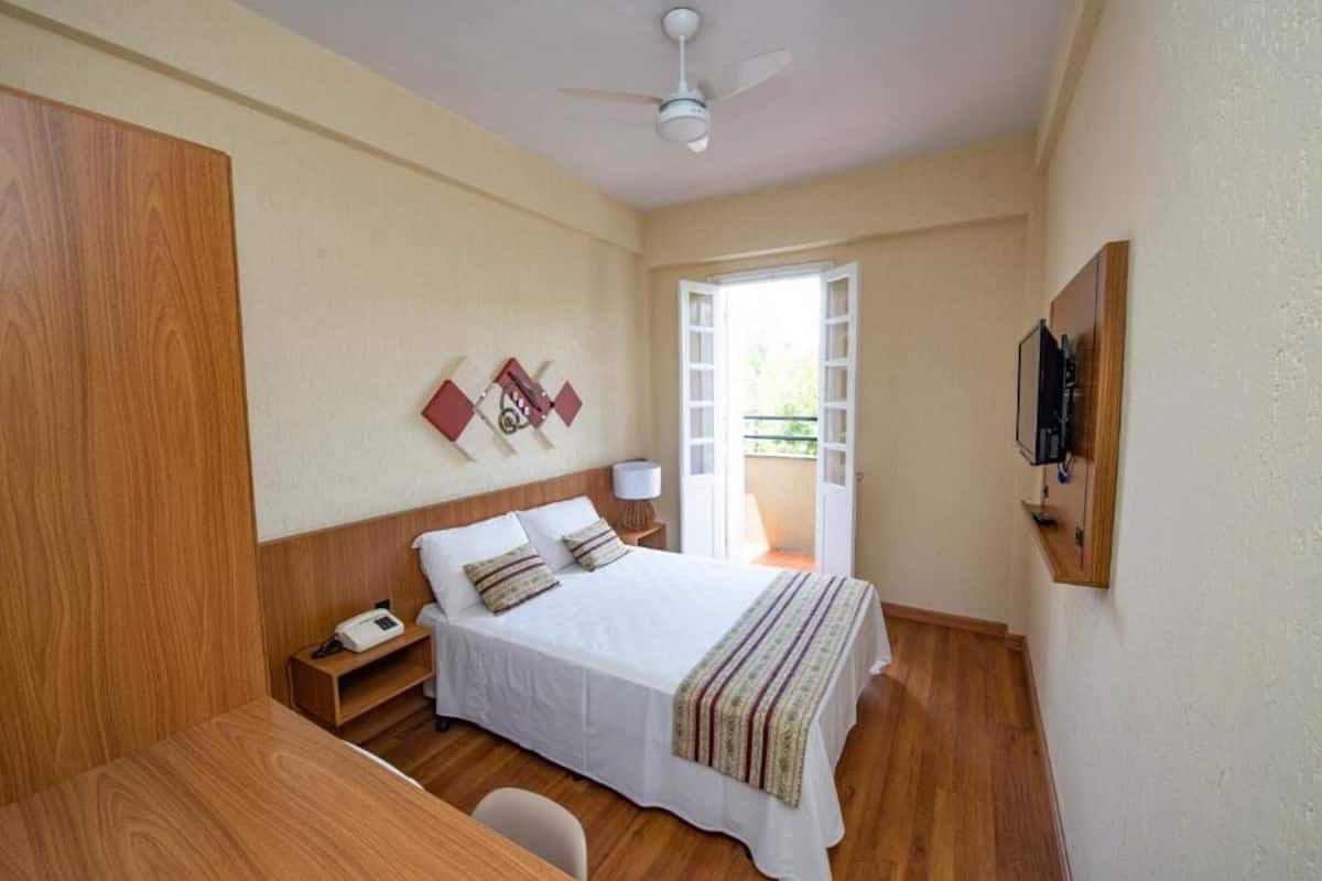 Ein Schlafzimmer mit Bett, Nachttisch und Deckenventilator.
