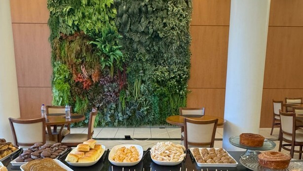 Un buffet proposant une variété de plats, notamment des pâtisseries et des sandwichs, dans une salle dont un mur est vert et qui est recouverte de lambris en bois.
