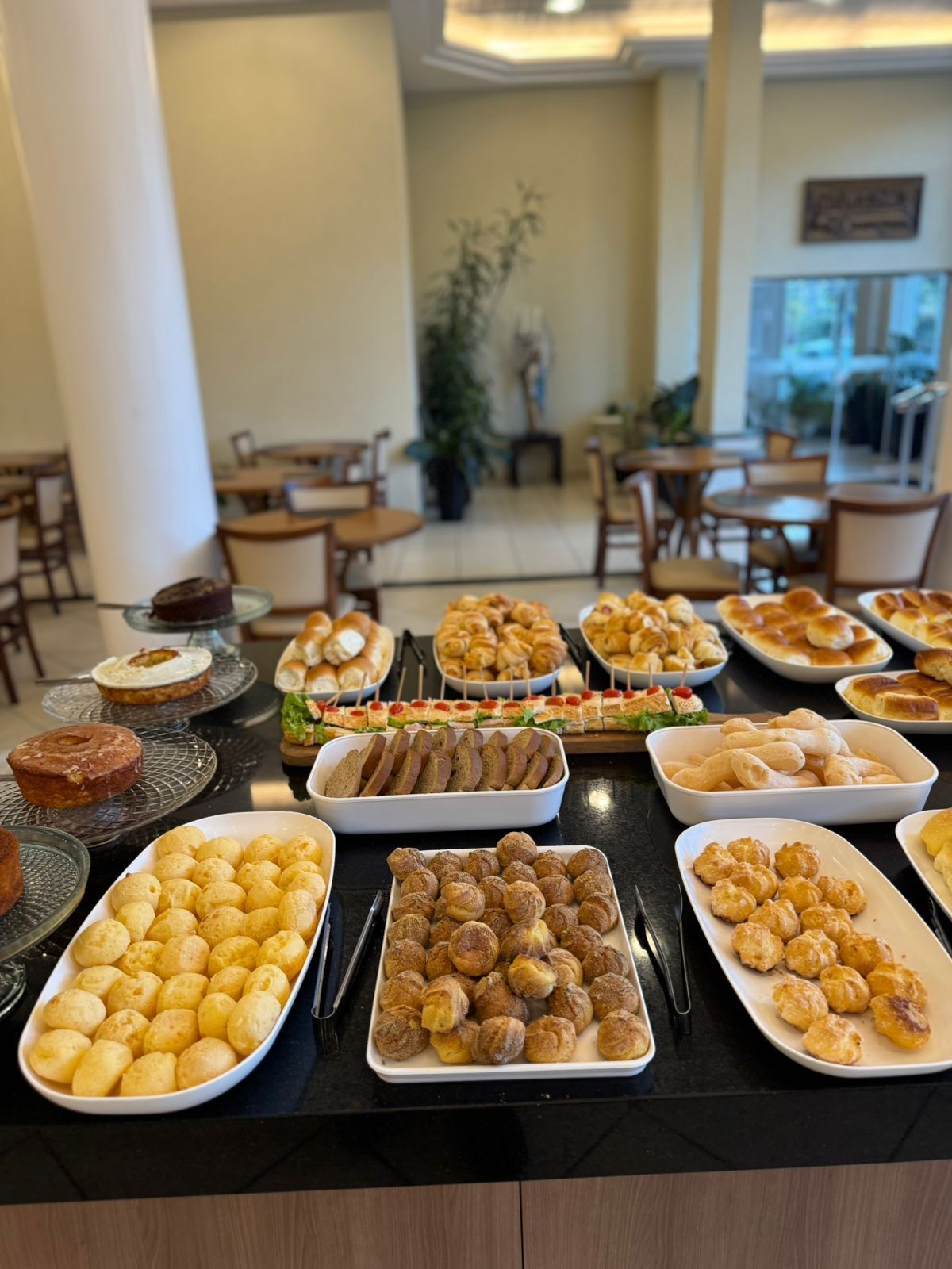 A buffet table with various baked goods and pastries.