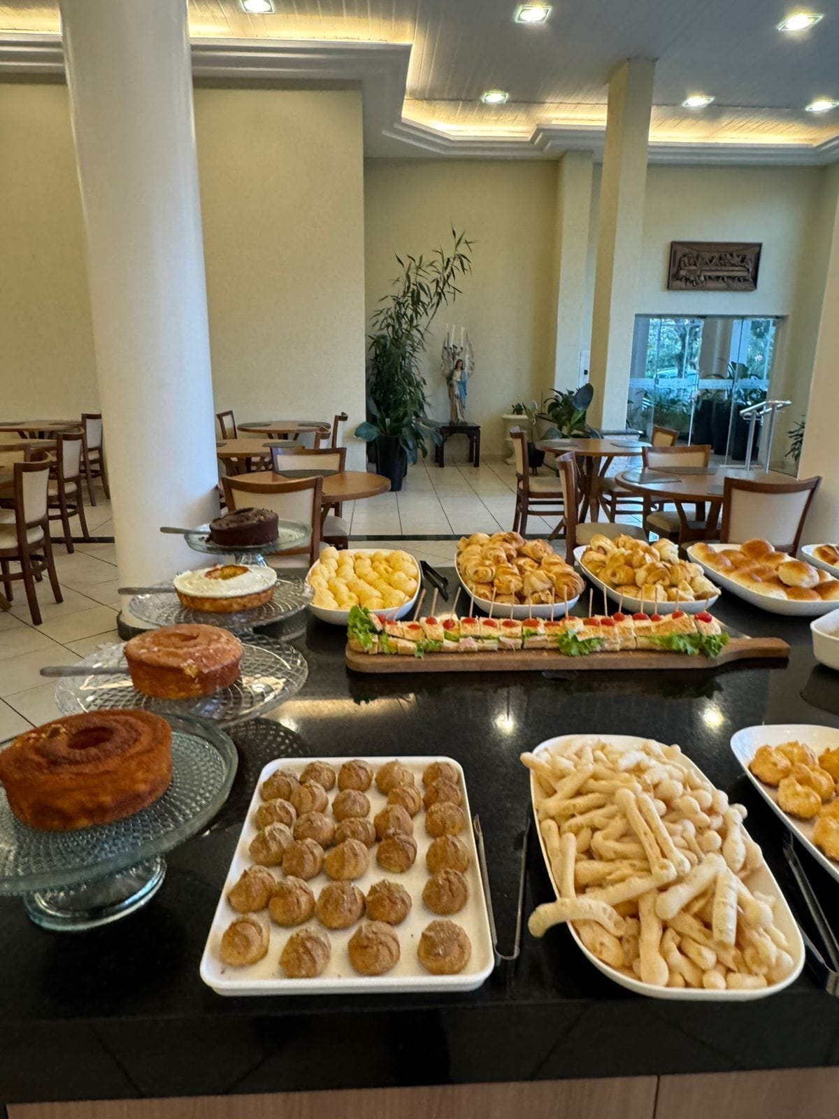 A buffet with various food items including pastries, meatballs, and French fries.