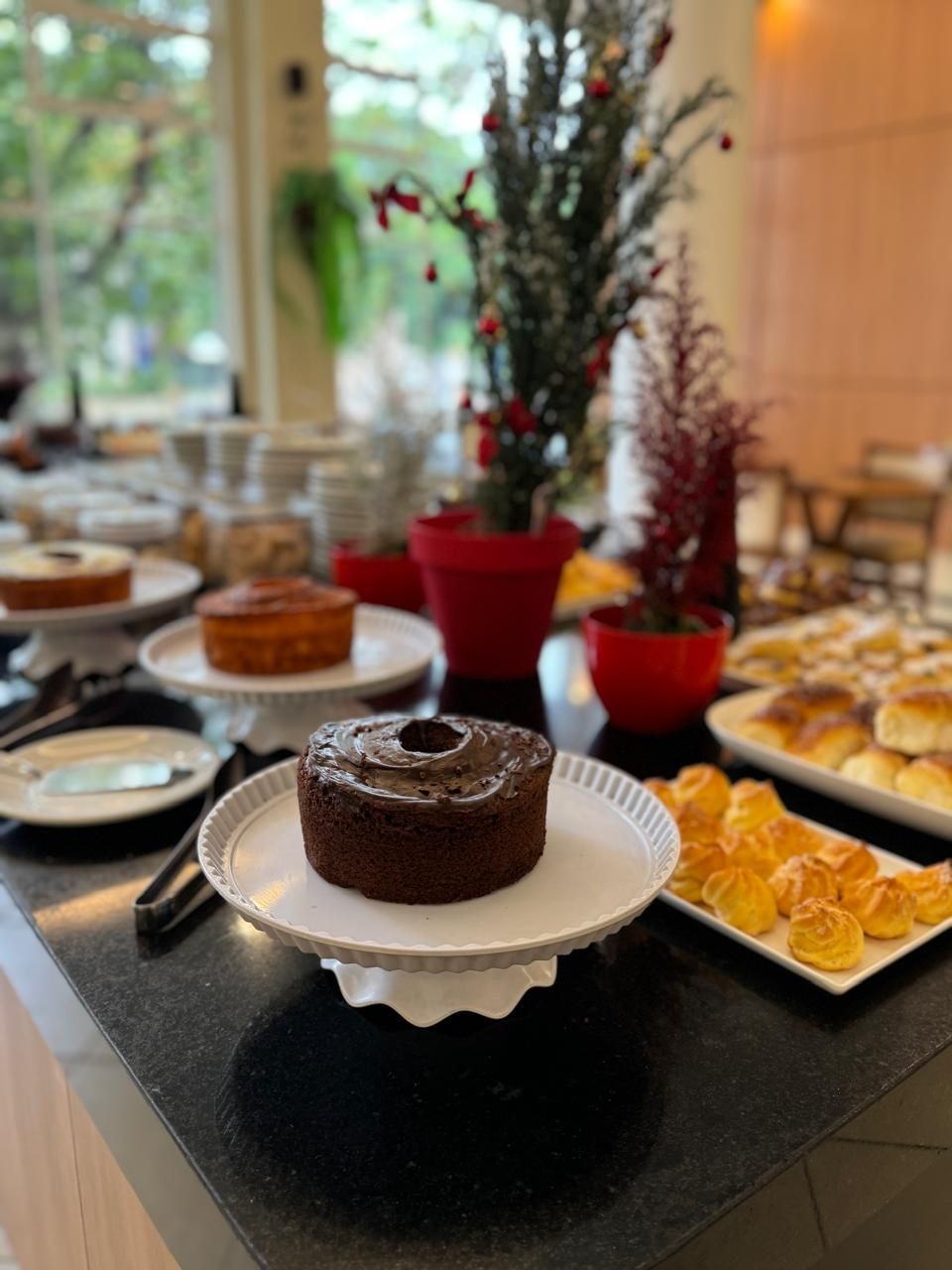 A buffet table with various desserts including a chocolate cake, pastries, and other baked goods.