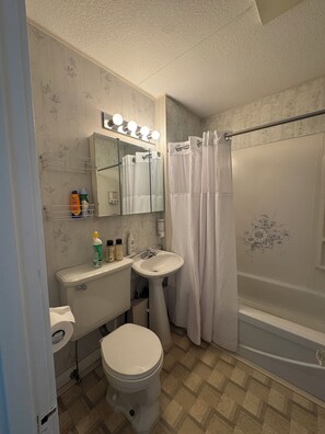 Un baño con inodoro, lavabo y bañera.