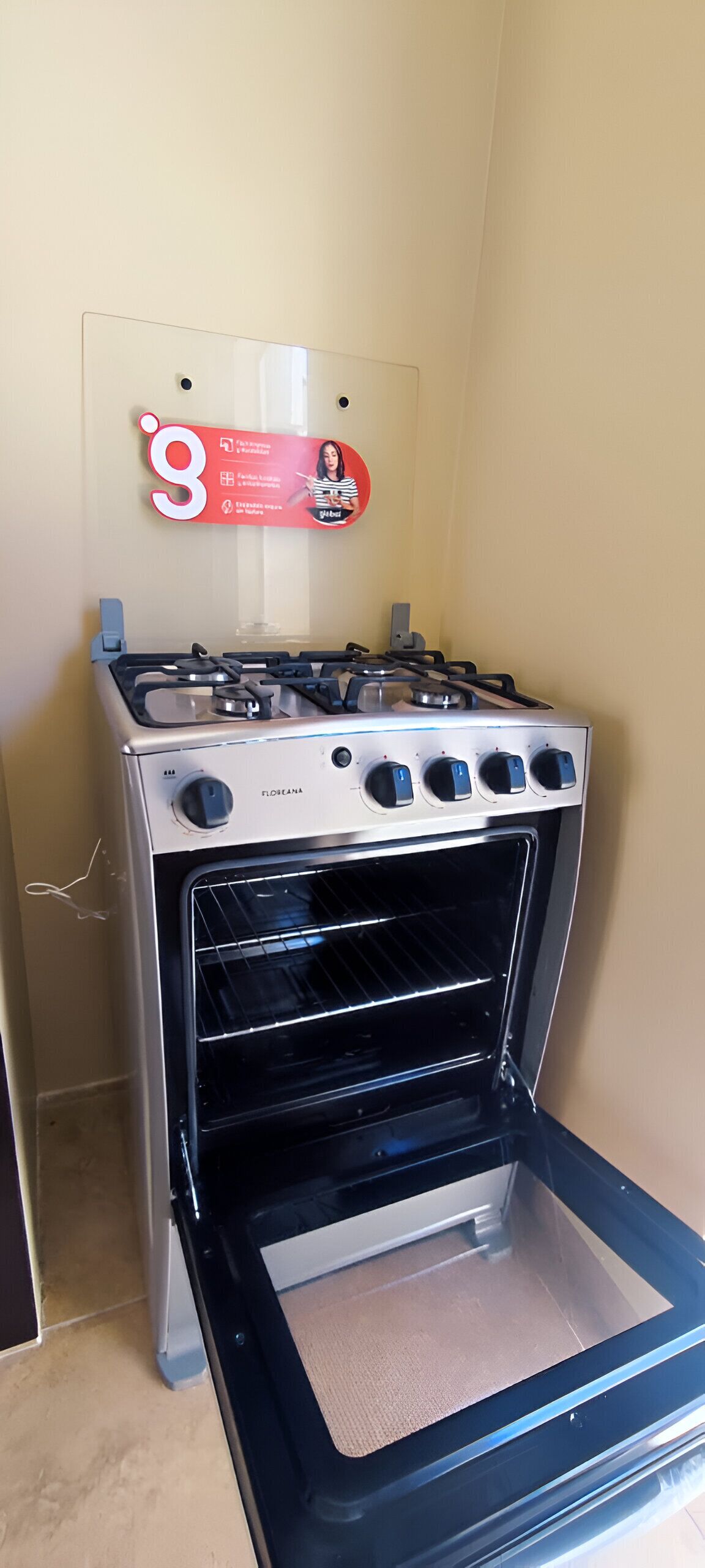 A kitchen with a stove and oven, a wall-mounted sign, and a door handle.