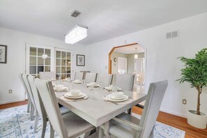 A dining room with a rectangular table set for six, surrounded by six chairs.