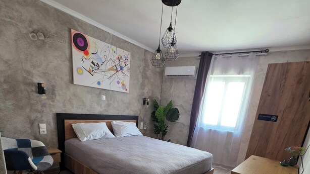 Un dormitorio moderno con una cama de madera, un escritorio, una planta y un cartel que dice 