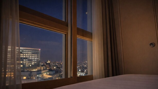 A hotel room with a large window offering a city view at dusk. - ALL STAY Myeongdong (Seoul)