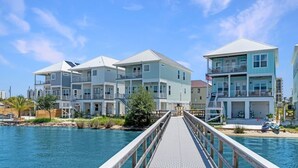 Een hotel aan het water met meerlaags gebouwen, een houten terras en een zwembad.