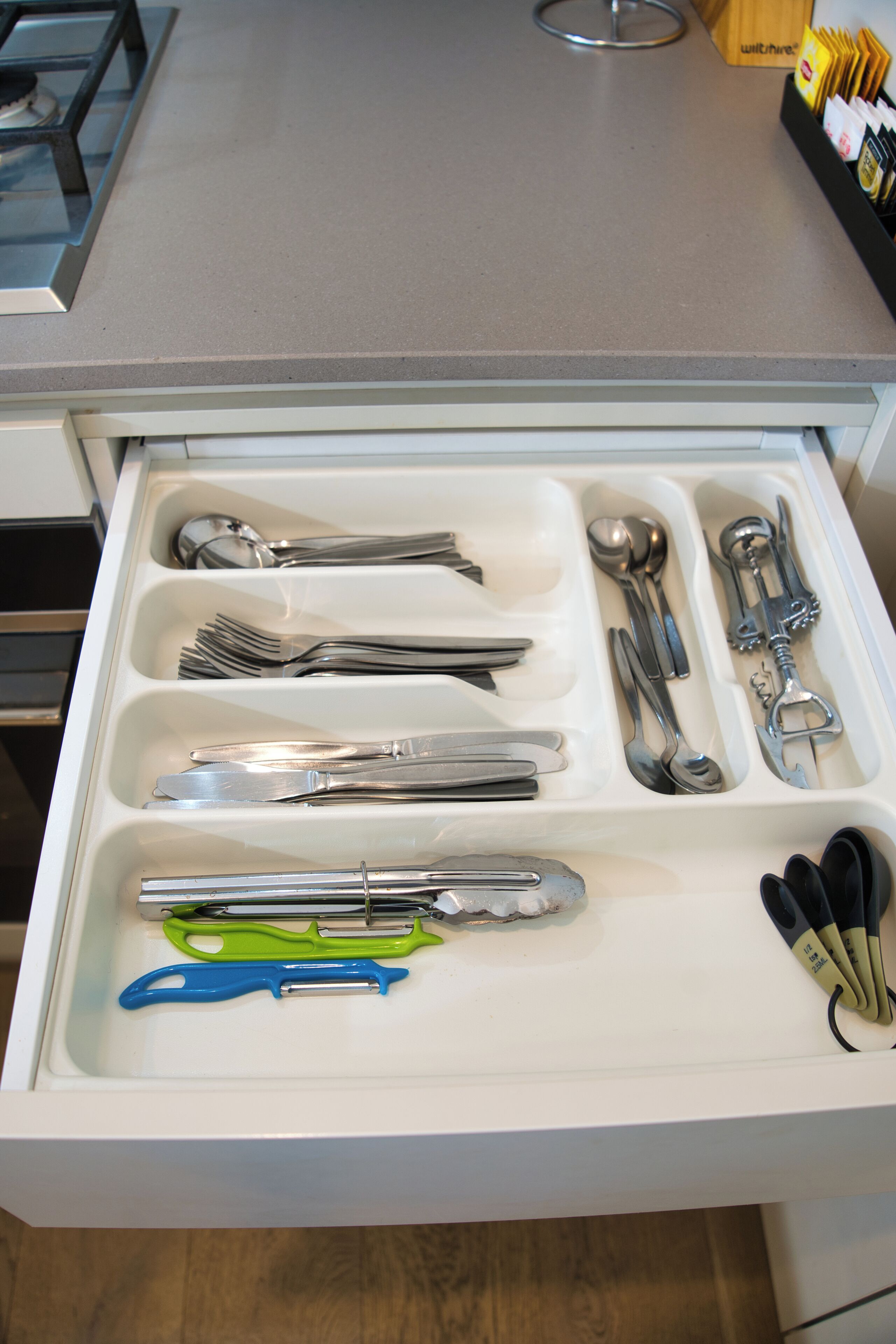 A drawer with various utensils neatly organized.