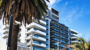 Un edificio moderno con balcones y un gran letrero 'CNE' en su fachada.