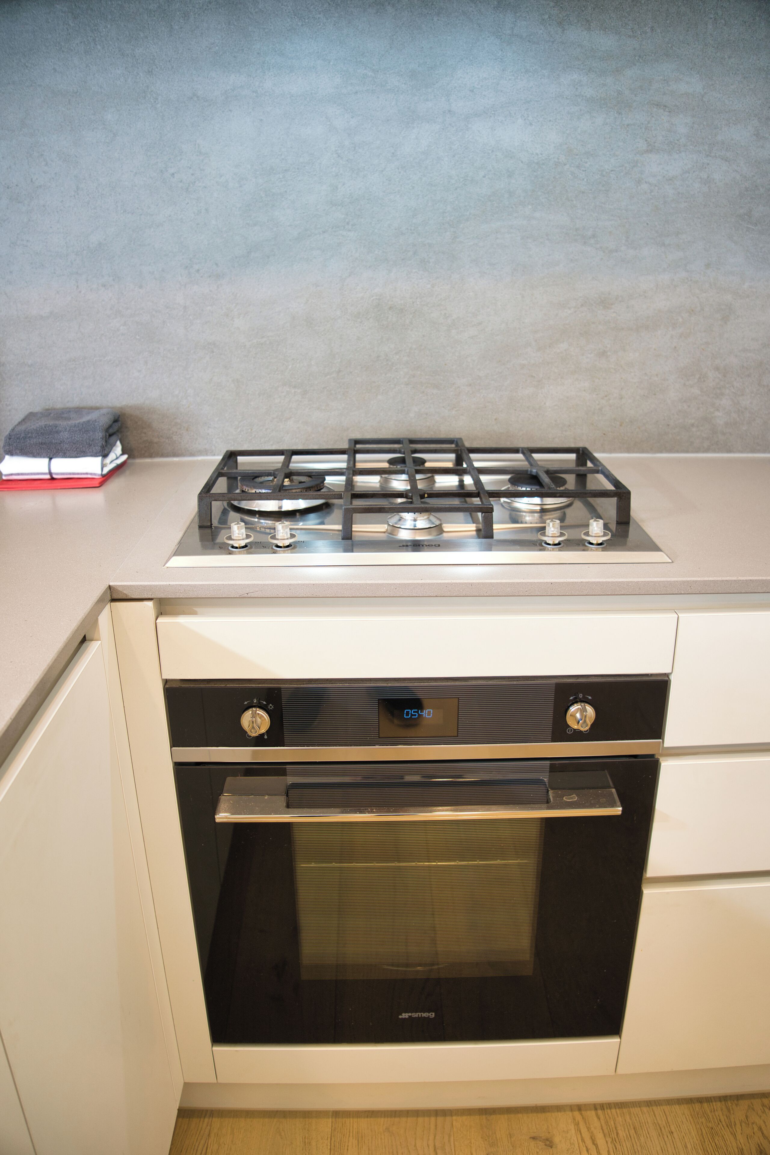 Una cucina con piano cottura a gas, forno e un ripiano.