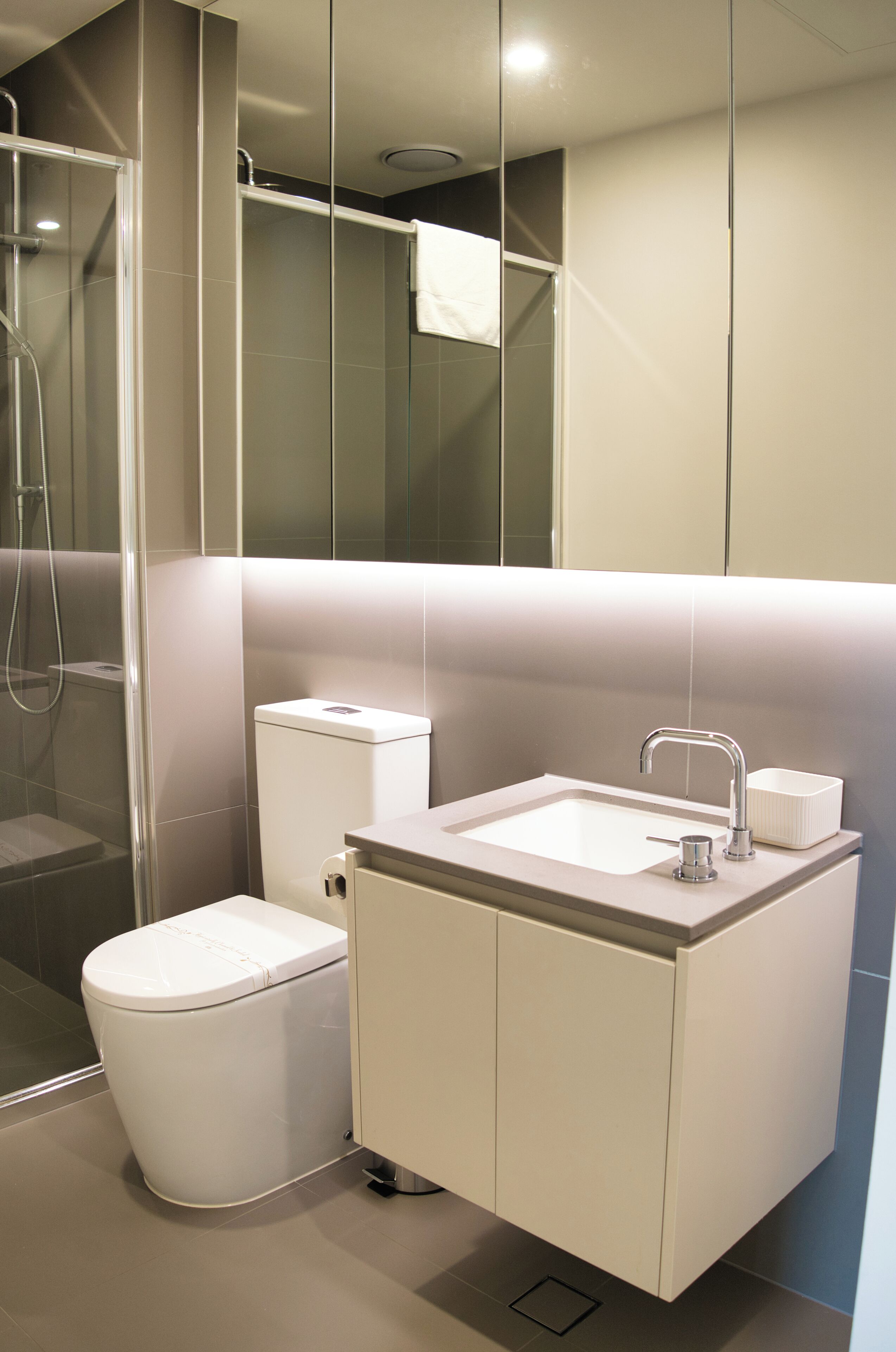 A modern bathroom with a toilet, sink, and shower.