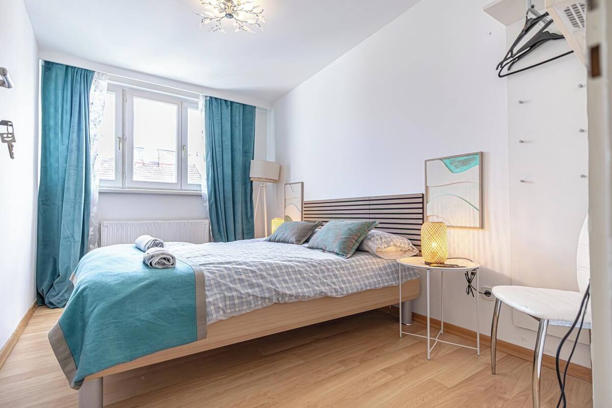 Ein ordentlich eingerichtetes Schlafzimmer mit einem Bett, einer Nachttischlampe und einem kleinen Tisch.