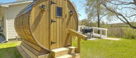 A wooden barrel-shaped structure with a door and steps leading up to it.