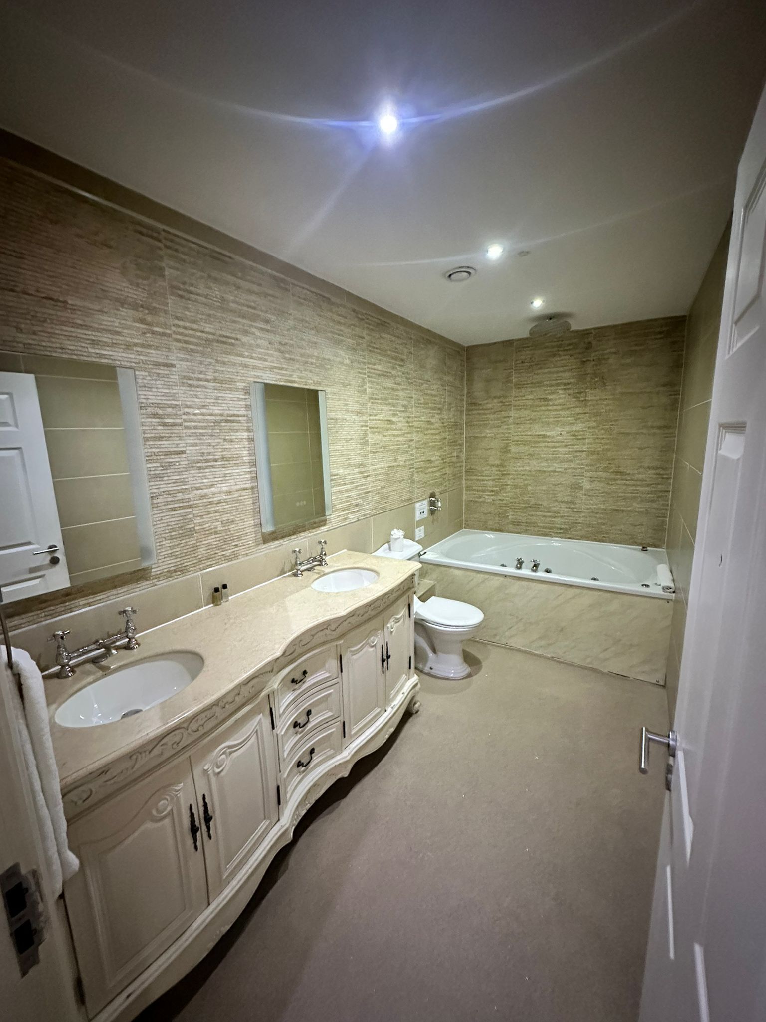 Un baño con dos lavamanos, inodoro y bañera.