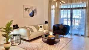 Een moderne woonkamer met een bank, een salontafel, een lamp en een potplant.