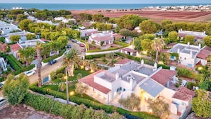 Un quartier résidentiel avec des maisons, une route et une plage en arrière-plan.