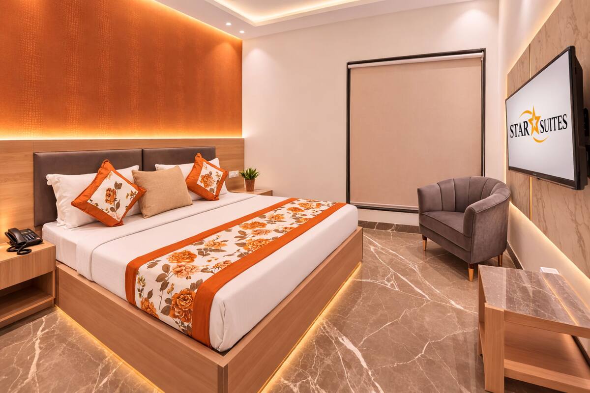 Een moderne hotelkamer met een groot bed, een bureau, een stoel, een televisie en een groot raam.