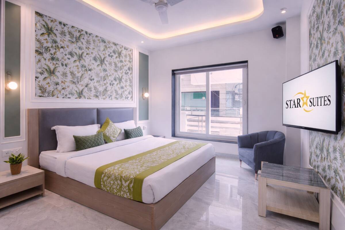 Een moderne hotelkamer met een groot bed, een flatscreen televisie, een bank en een kleine tafel.