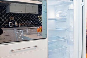 A kitchen with a refrigerator, a microwave, and a sink.
