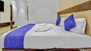 A hotel room with a bed, a flat-screen TV, and an air conditioning unit. - Hotel Karpagam Lodging house (Coimbatore)