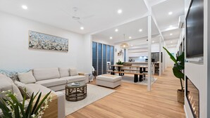Un salon moderne avec un canapé, une table basse et un coin repas agrémenté d’un banc.