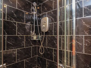 A shower with a handheld showerhead and a handheld shower attachment.