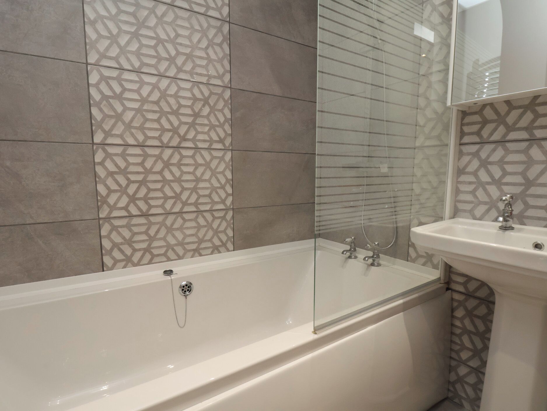 A modern bathroom with a freestanding bathtub, a glass shower enclosure, and a sink with a mirror.
