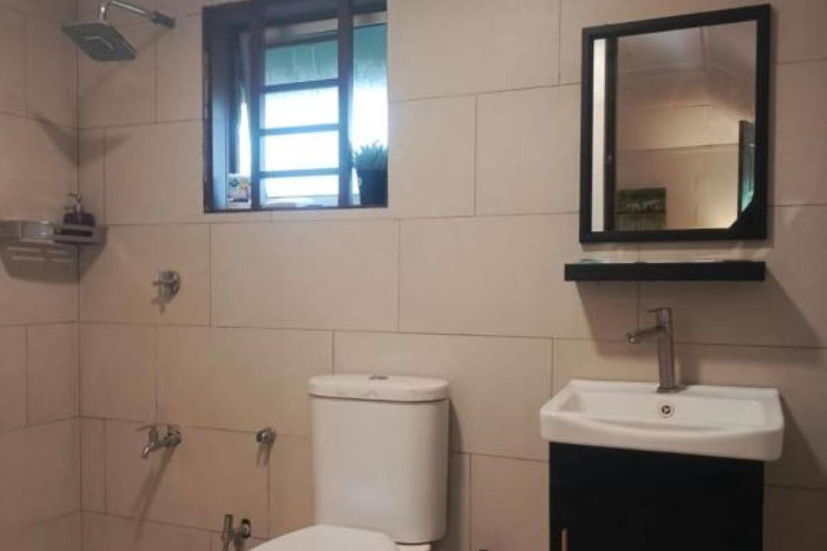 Une salle de bain équipée de toilettes, d’un lavabo et d’une douche.