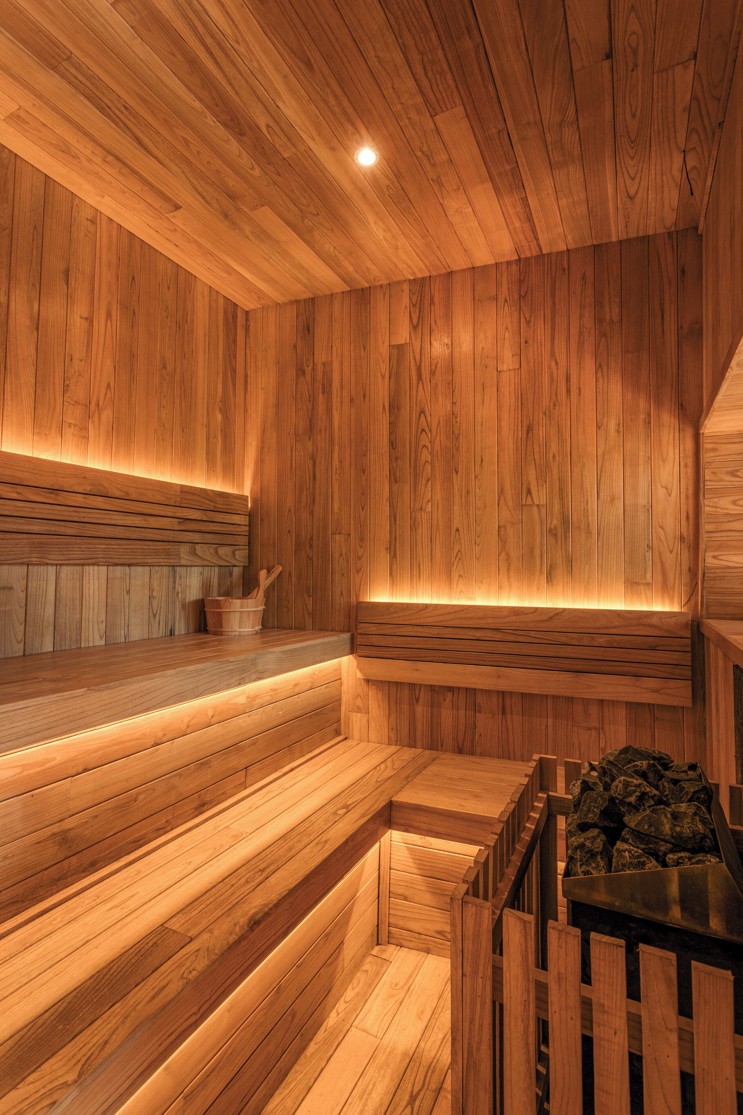 A wooden sauna with benches and a stone basin.