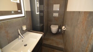 A bathroom with a sink, mirror, toilet, and towel rack.