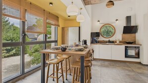 Una cocina moderna con una isla grande, taburetes de madera y vistas al exterior.