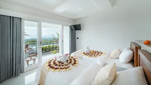Habitación de hotel moderna con un amplio ventanal corredera que da a un balcón y vistas panorámicas.