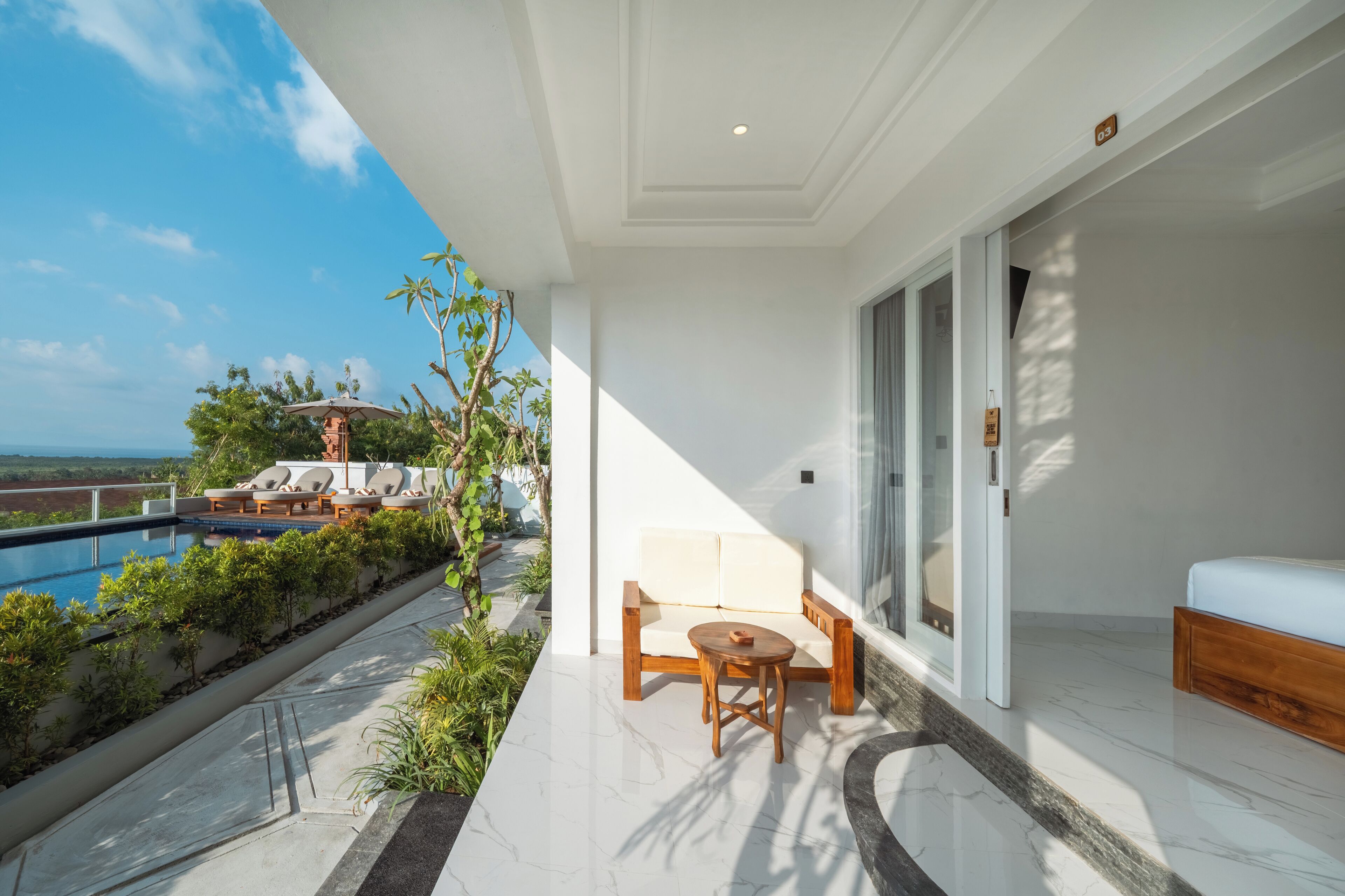 Ein Balkon mit Pool, einer Couch, einem Tisch und einem Bett.