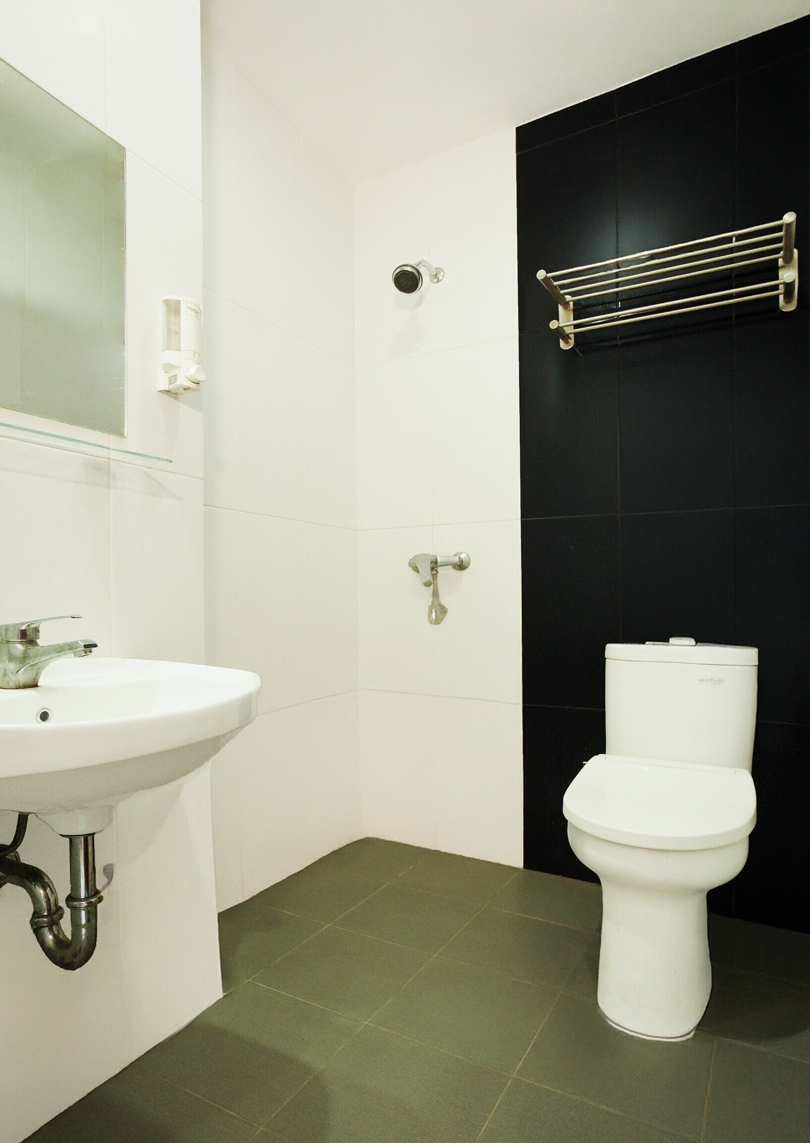 Een badkamer met een wit wastafel, een spiegel, een toilet en een douche.