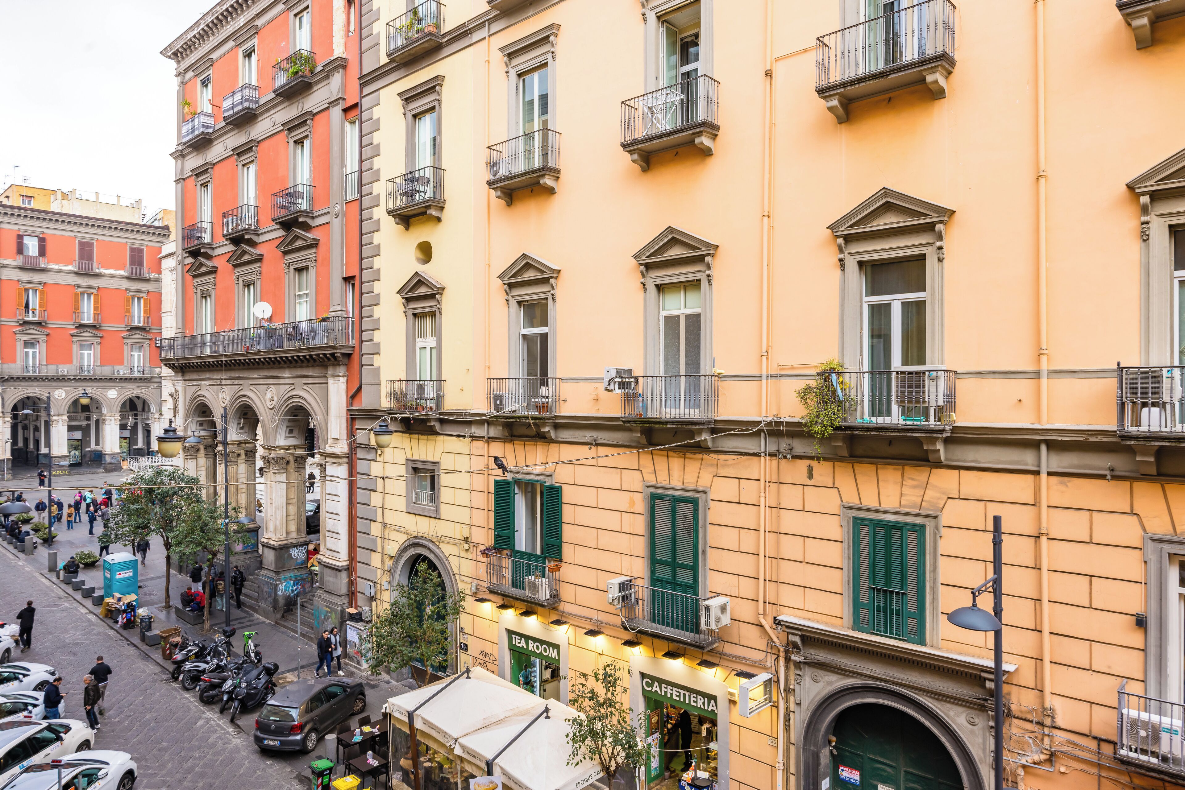 Vista de una calle con un edificio amarillo que tiene una cafetería y una sala de té.