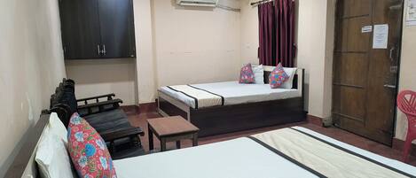 A room with a bed, a desk, a wardrobe, and a door.