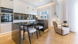 A modern kitchen with a marble countertop, stainless steel appliances, and pendant lighting. - Michalakopoulou Cover & Bright Apartment (Athens)