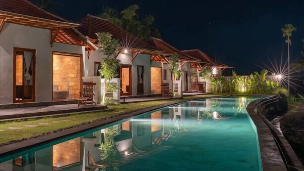 A poolside view of a resort with multiple villas, each with a private entrance and outdoor seating area. - Tumbu Retreat (Karangasem)
