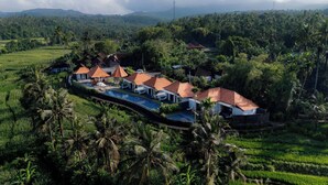 A resort with multiple bungalow-style buildings, a swimming pool, and lush tropical surroundings. - Tumbu Retreat (Karangasem)