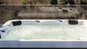 A hot tub with a clear view of a mountainous landscape in the background. - Neaira Apartments (Platanias)