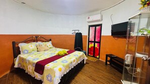 A bedroom with a bed, a TV, a wardrobe, and a door with a colorful window. - Capital O 91187 D'dusun Raudhah Chalet (Baling)